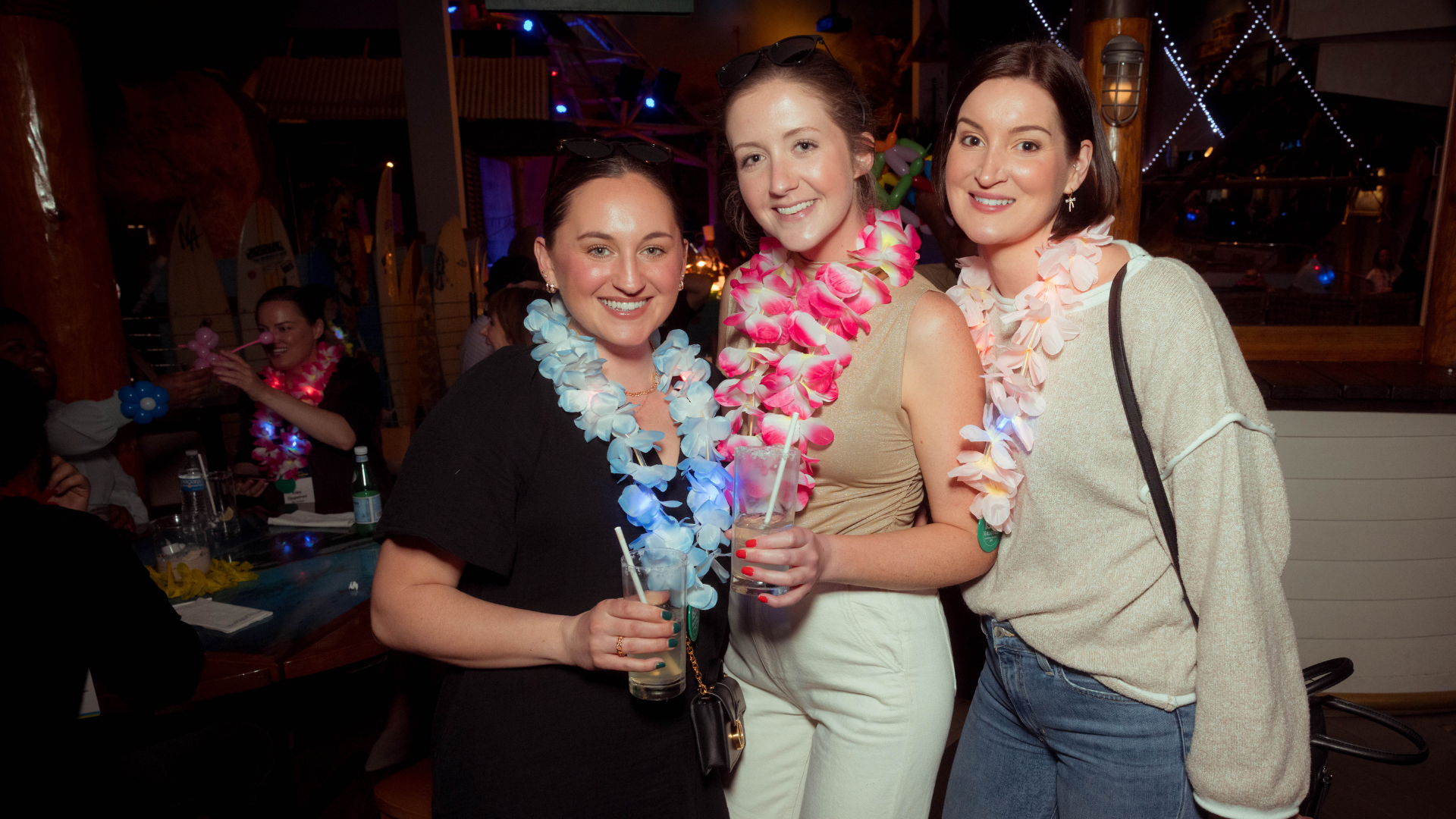 Attendees smile for a photo wearing sunglasses